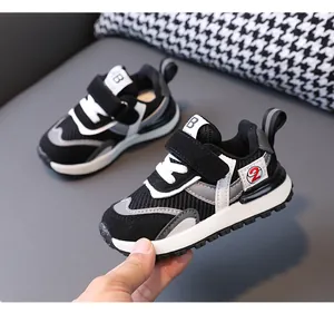 Side view of toddler mesh sneakers with velcro strap, white soles, and black grey design
