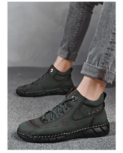 Men's stylish dark green high-top work boots styled with trendy gray denim jeans