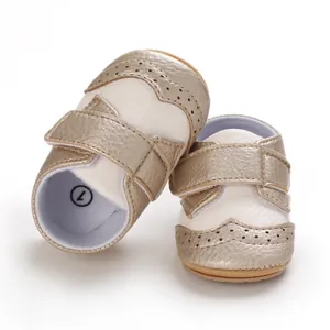 Close-up detail of champagne gold and cream baby brogue shoes with secure straps