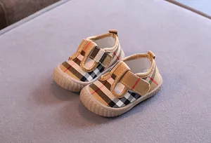 Detailed view of soft-soled baby toddler shoes featuring a classic plaid pattern