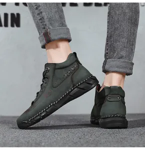 Macro view of dark green men's high-top leather boots with hand-stitched detailing