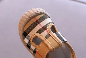Macro view of toddler canvas walking shoes featuring classic plaid and soft rubber sole