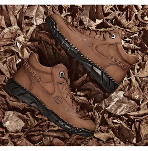 Detailed macro view of brown leather Martin boots on autumn leaves background.