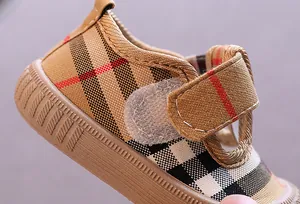 Close-up of toddler canvas shoes with classic plaid pattern and Velcro strap.