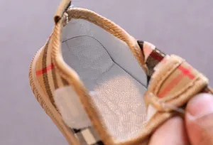 Detail view of breathable baby walking shoes with classic plaid pattern and soft lining.
