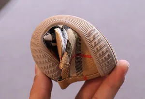 Close-up of flexible soft sole baby walking shoes with classic plaid canvas pattern