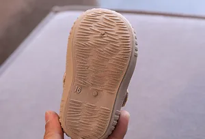 Macro detail showing the anti-slip texture of baby toddler shoe sole in brown