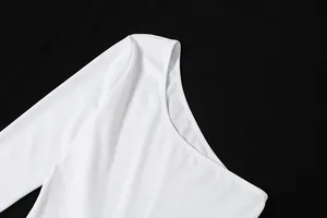 Détail de l'élégante encolure asymétrique de ce combishort blanc à manches longues en mesh