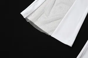 Gros plan détaillé du patchwork en maille blanche sur une combinaison évasée tendance