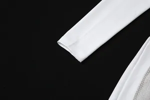 Gros plan détaillé d'une combinaison blanche à manches longues avec maille argentée.