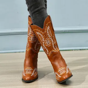 Close-up of brown mid-calf Western cowboy boots with white and yellow embroidery