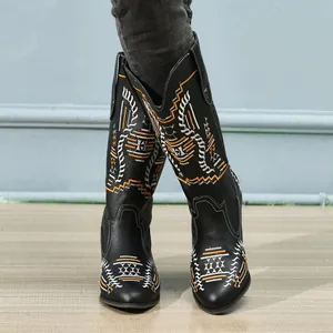 Close-up of black mid-calf boots with intricate ethnic embroidery patterns