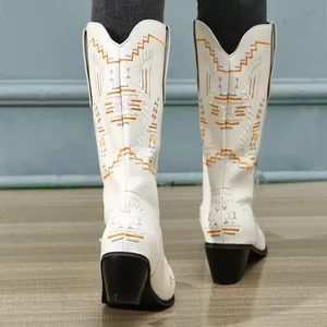 Back view of white mid-calf cowboy boots with intricate orange embroidery detail