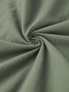 Close-up of soft green cotton blend fabric texture for men's lightweight lounge robe sleepwear.