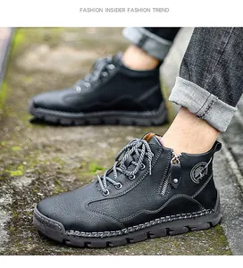 Close-up of men's black leather outdoor work boots with side zipper and thick rubber sole