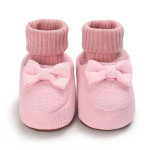 Gros plan de chaussures roses pour bébé avec nœud mignon et texture tricotée douce