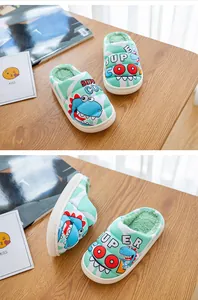 Detailansicht von mintgrünen Kinder-Hausschuhen mit Dinosaurier-Print und warmem Futter.
