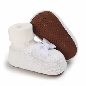 Détail de chaussons blancs pour bébé en tricot avec semelle souple antidérapante