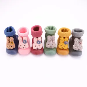 Detalle de zapatos calcetín para bebé con diseño de conejo y forro de felpa