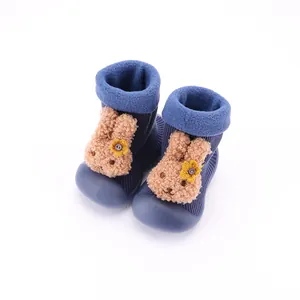 Primer plano de zapatos tipo calcetín para bebé con conejo de peluche