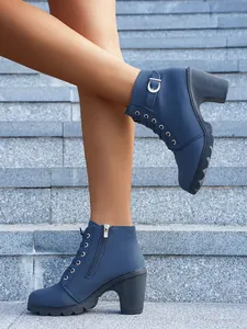 Detailaufnahme blauer Schnürstiefeletten mit Blockabsatz und Reißverschluss auf Steinstufen.