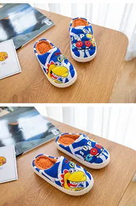Detailansicht von Kinderhausschuhen mit blauem Streifenmuster und Dinosaurier-Motiv