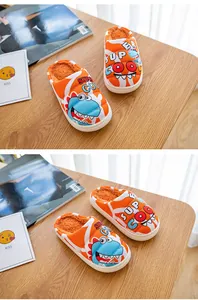 Detailansicht orangefarbener Kinderschuhe mit blauem Dinosaurier-Design und Futter