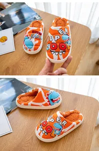 Detailansicht von warmen Kinderhausschuhen mit Dino-Motiv und weichem Fellfutter.