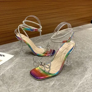 Detailed macro view of the sparkling rhinestone bow on rainbow transparent high heel sandals