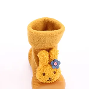 Primer plano de calcetín zapato para bebé amarillo con conejo de felpa y forro polar