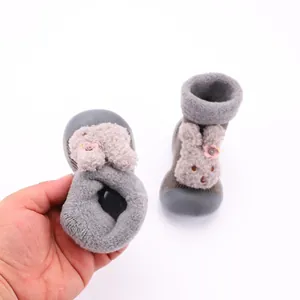 Primer plano de calcetines zapato para bebé con conejo de peluche y tejido suave.