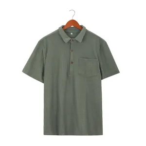 Close-up of green waffle-knit men's short-sleeved polo shirt with lapel and pocket detail
