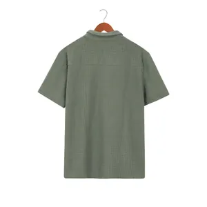 Rear view of a sage green waffle knit men's short sleeve shirt on a wooden hanger