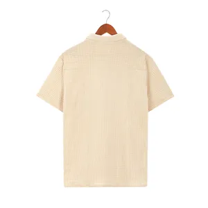 Close-up back view of a men's beige waffle knit short sleeve shirt on a hanger