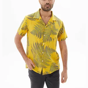 Close-up of a men's yellow casual short-sleeved shirt with fern leaf prints on a model