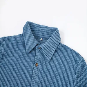 Close-up detail of a blue waffle knit polo shirt showing texture and buttons
