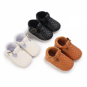 Detail von gewebten Baby-Lauflernschuhen in Schwarz, Weiß und Braun mit T-Riemen