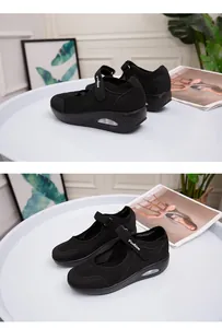 Detailed view of black breathable mesh rocker shoes with velcro strap on table.
