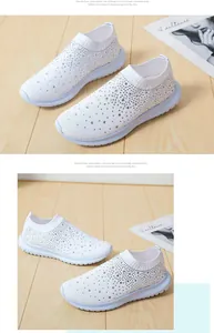 Weiße Sneaker mit Strasssteinen und Strickobermaterial zeigen funkelnde Kristalldetails.