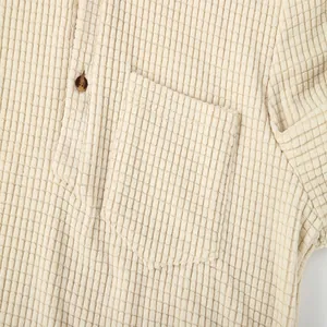 Close-up detail of beige waffle knit texture on men's button-down casual shirt pocket