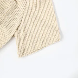 Macro view of beige waffle knit fabric texture on men's casual summer shirt sleeve