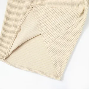Detailed close-up of cream waffle knit fabric texture and hem on a men's casual shirt