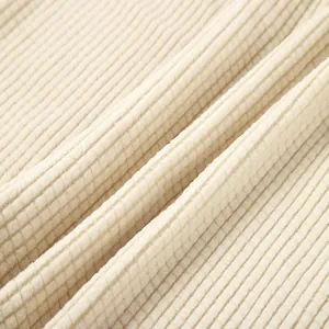 Detailed macro view showing the soft beige waffle knit fabric texture of a men's shirt