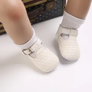 Nahaufnahme von weiß gewebten Lauflernschuhen für Babys mit verstellbarer Schnalle