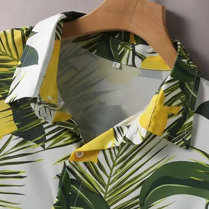 Primo piano di camicia da uomo a maniche corte con stampa di foglie tropicali vivaci.