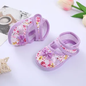 Close-up detail of purple floral baby walking shoes featuring soft soles and bows