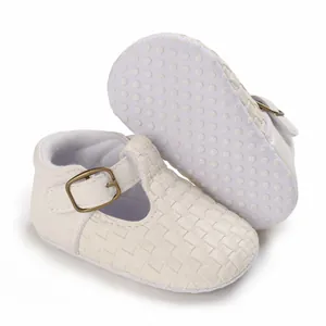 Detaillierte Nahaufnahme weißer gewebter Babyschuhe mit einer rutschfesten Noppensohle.