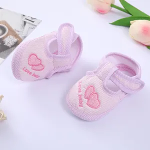 Detail of pink striped baby walking shoes with embroidered heart and Love baby text