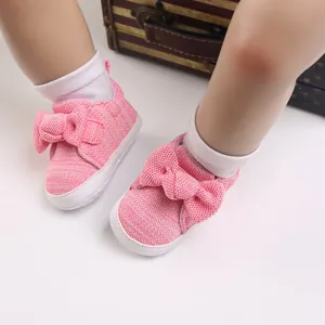 Detailed view of pink woven baby walking shoes with a decorative bow for toddlers