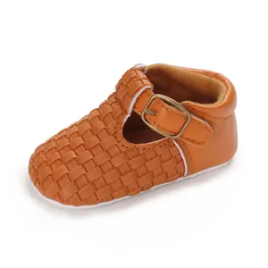 Nahaufnahme von braunem gewebtem T-Riemen Babyschuh mit verstellbarer Metallschnalle